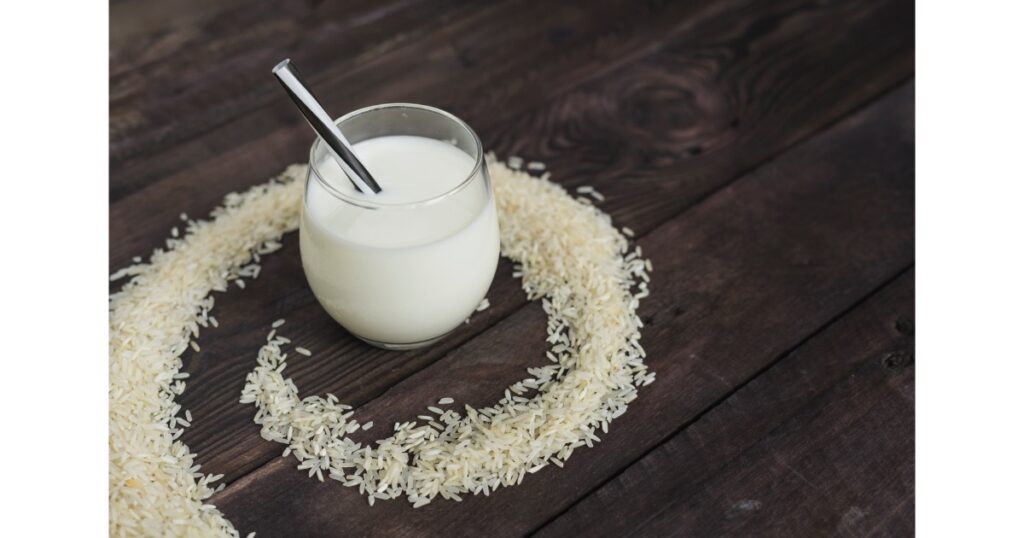 refreshing rice milk glass with straw placed circular frame raw rice background