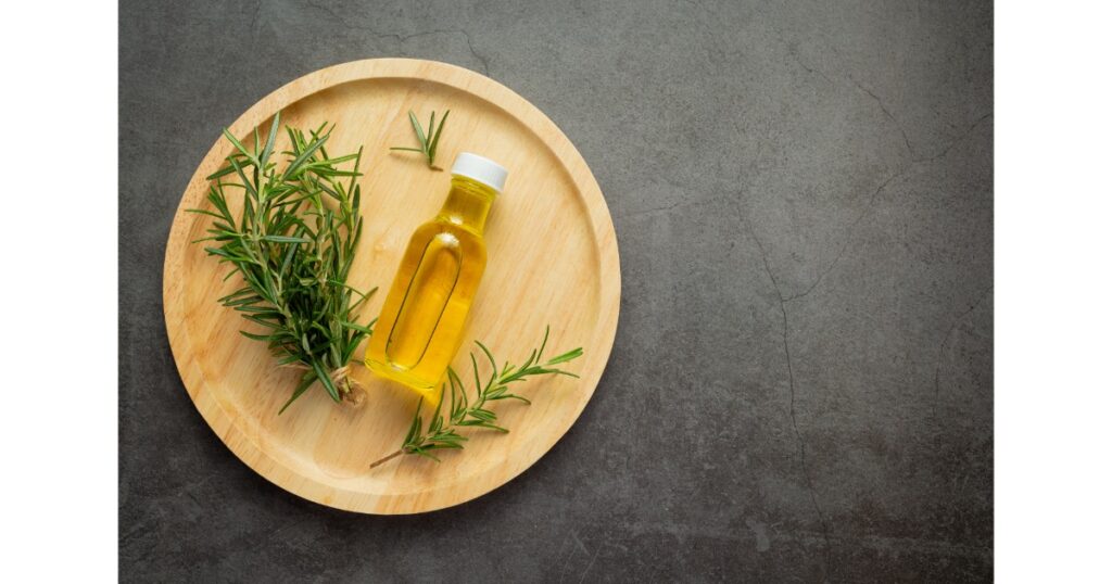 rosemary oil bottle with rosemary plants